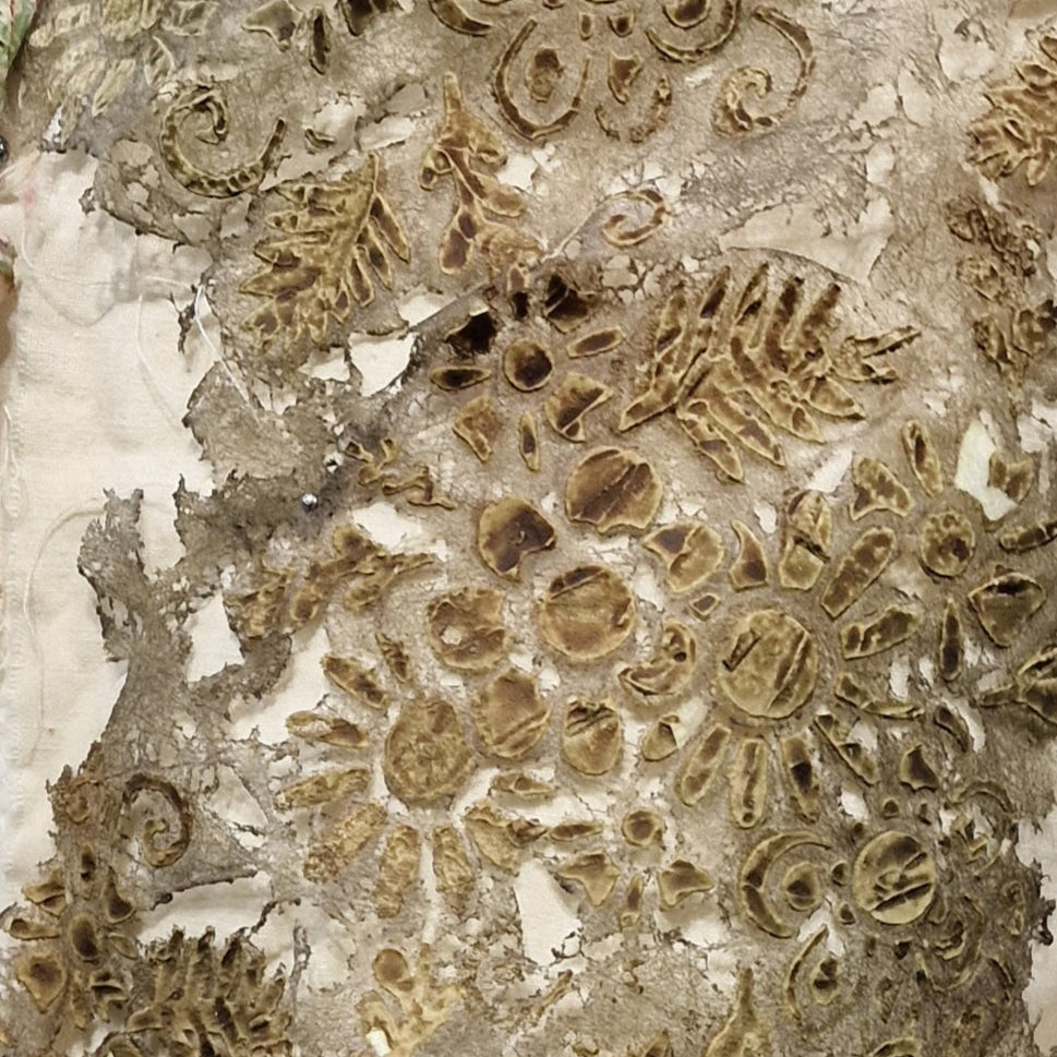 Close-up of a textured, woven fabric with a floral pattern, workded Lutradur fabric. Used at a workshop at Eau Brink Studio