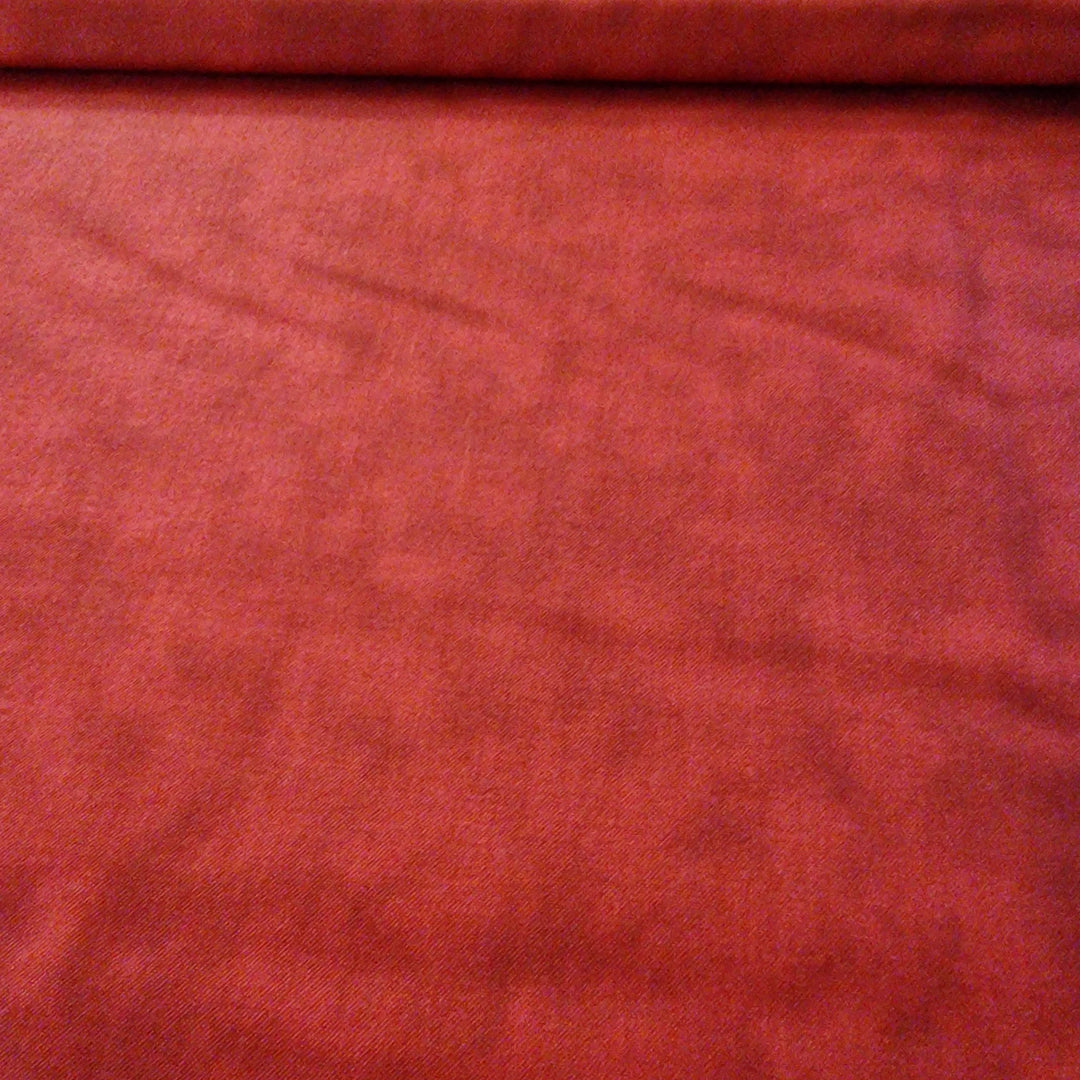 A piece of red printed cotton fabric with a textured pattern, laid flat. A great filler for quilts. Available at Eau Brink Studio