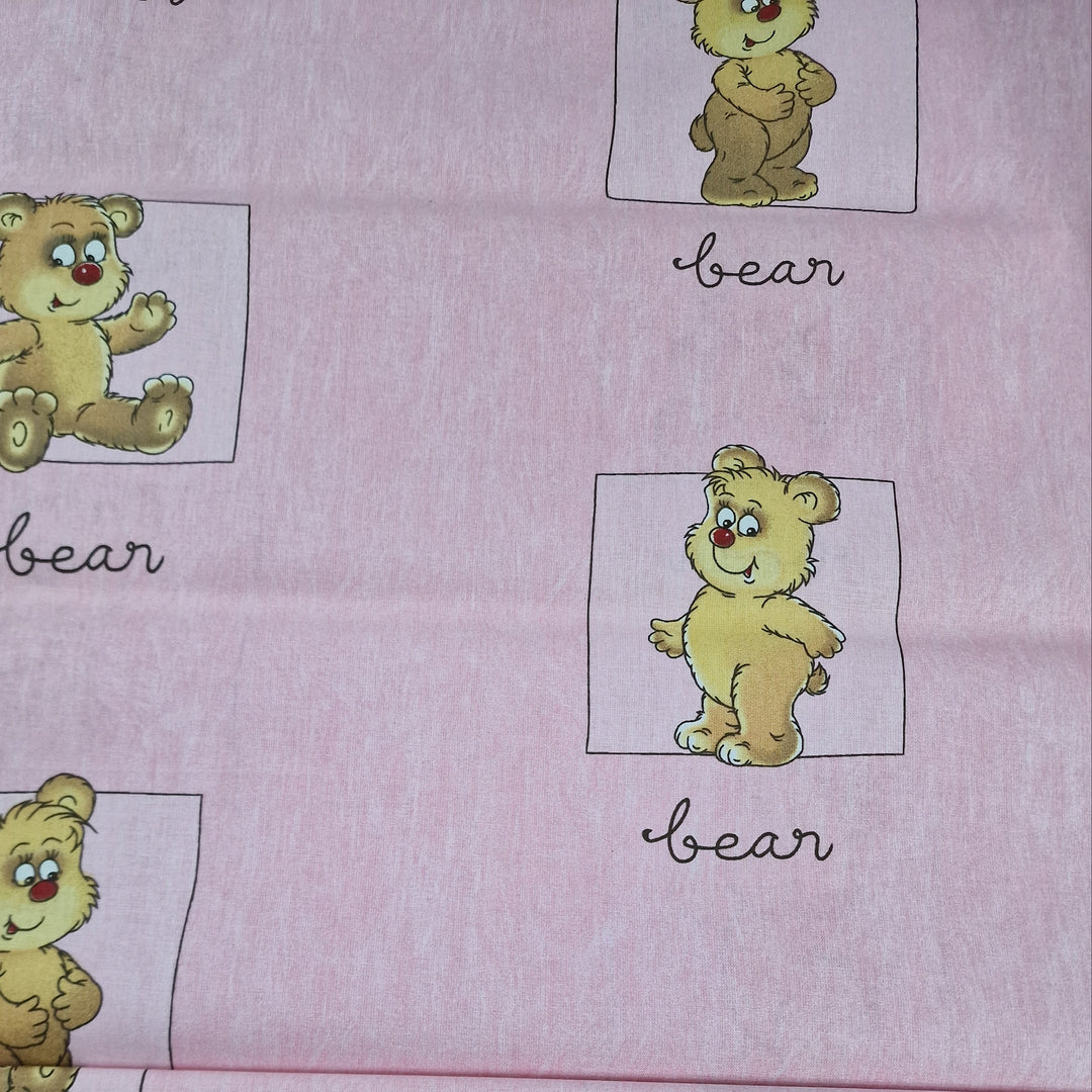 Fabric featuring a repeated pattern of a cute, cartoon-style bear in various shades of pink, with the word 'BEAR' written above each bear. The fabric has a pink background and is folded neatly.