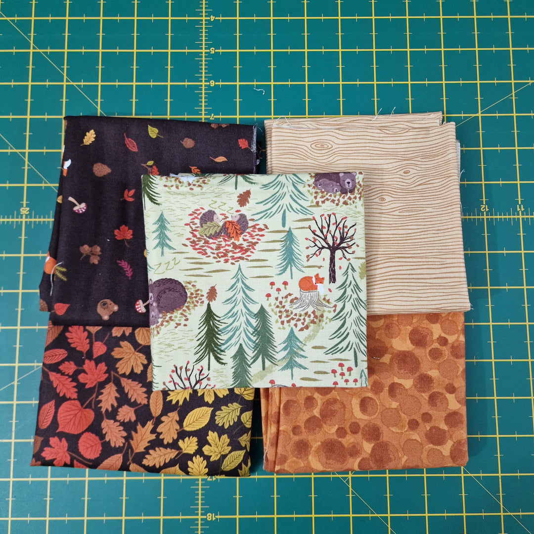 Collection of fabric swatches on a cutting mat with grid lines